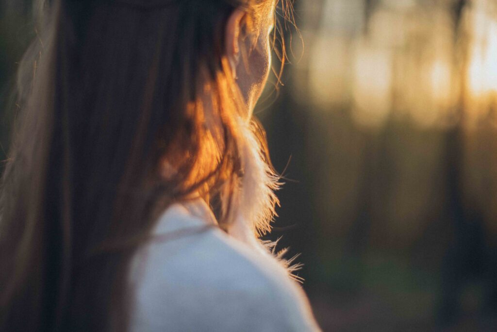 Back view of a thoughtful woman at sunset, representing dealing with loneliness and single life.